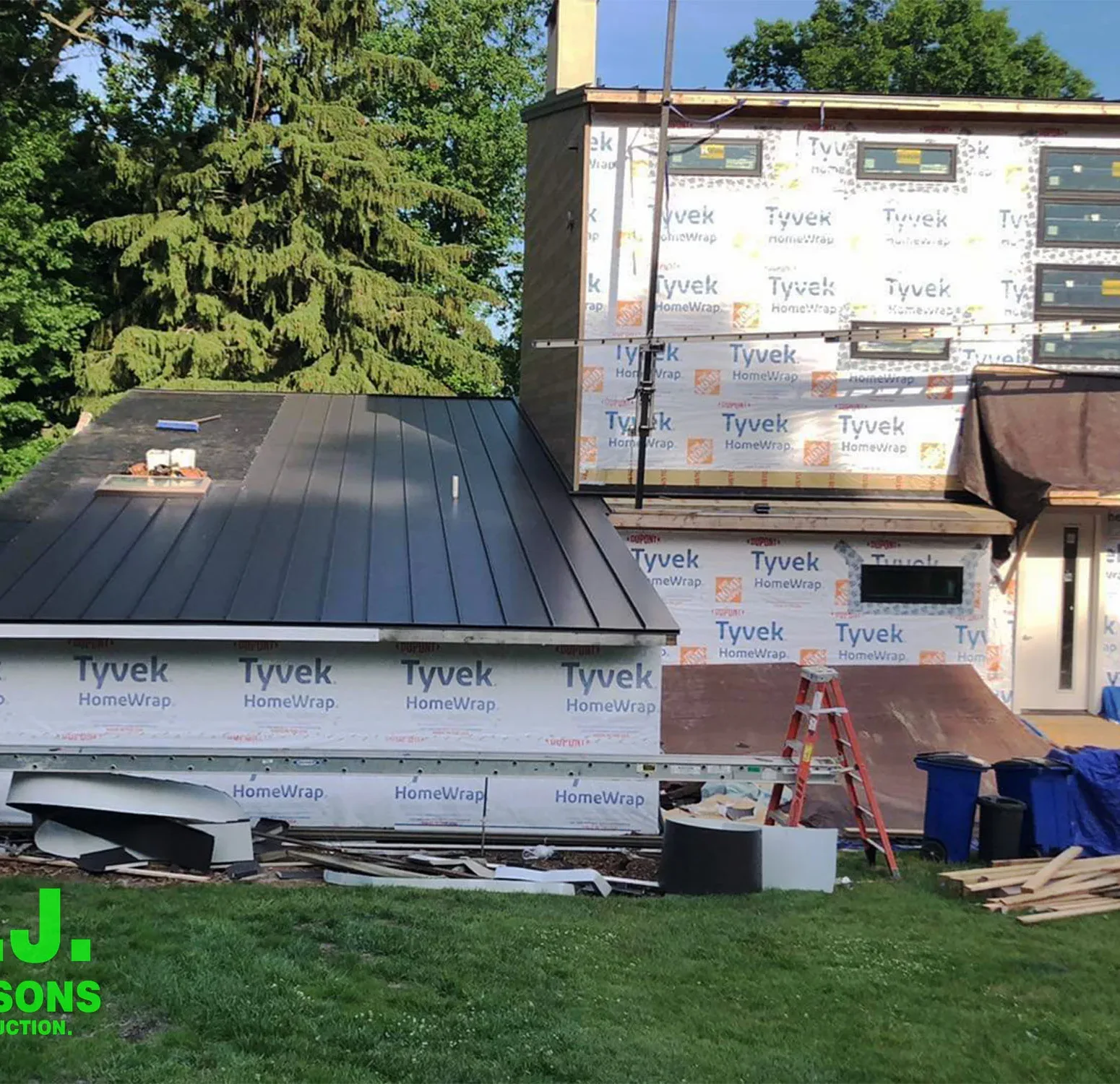 a residential construction site, emphasizing the house in its raw state with house wrap in preparation for the upcoming installation of Nichiha siding