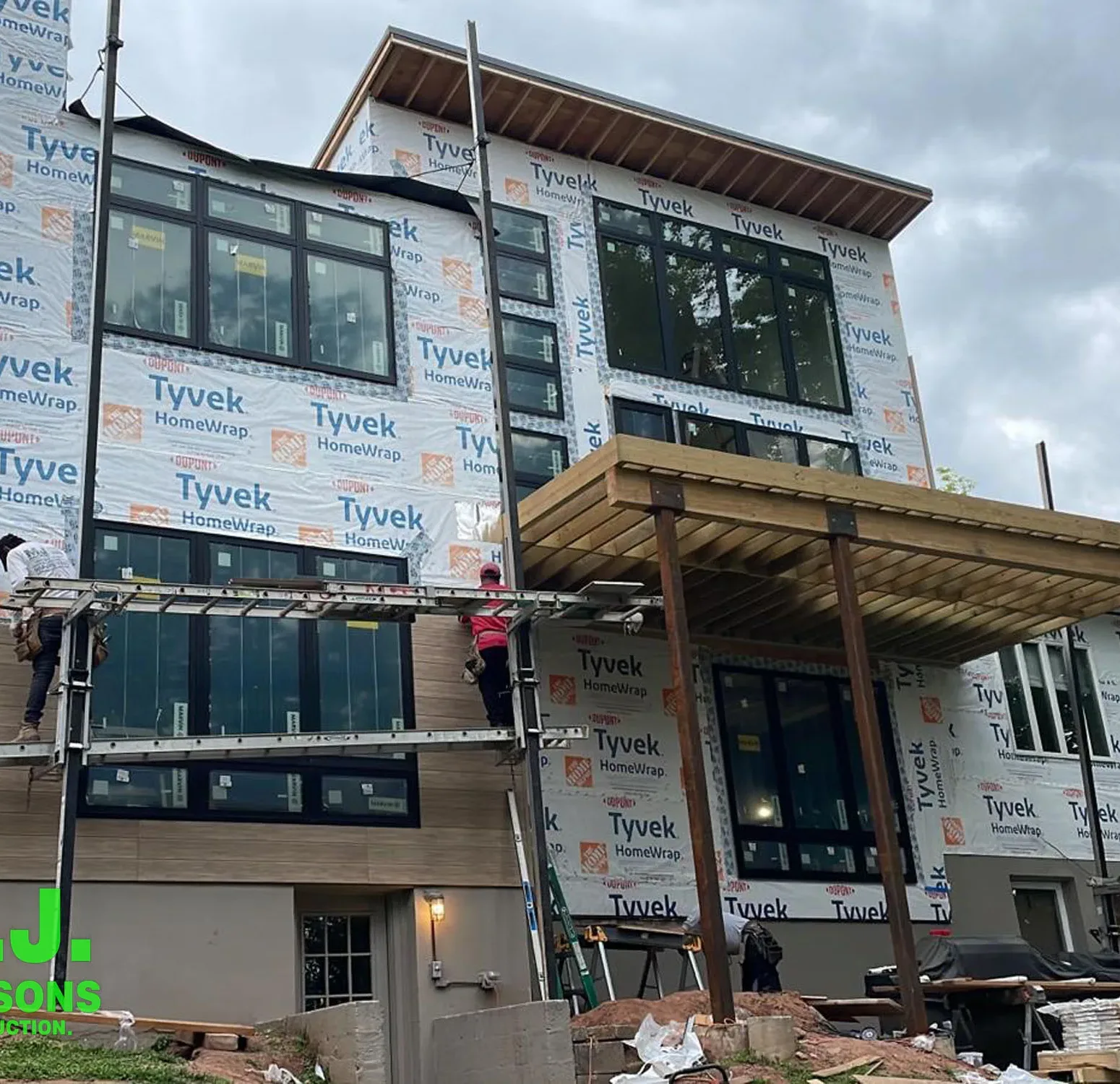 a residential construction site, emphasizing the house in its raw state with house wrap in preparation for the upcoming installation of Nichiha siding