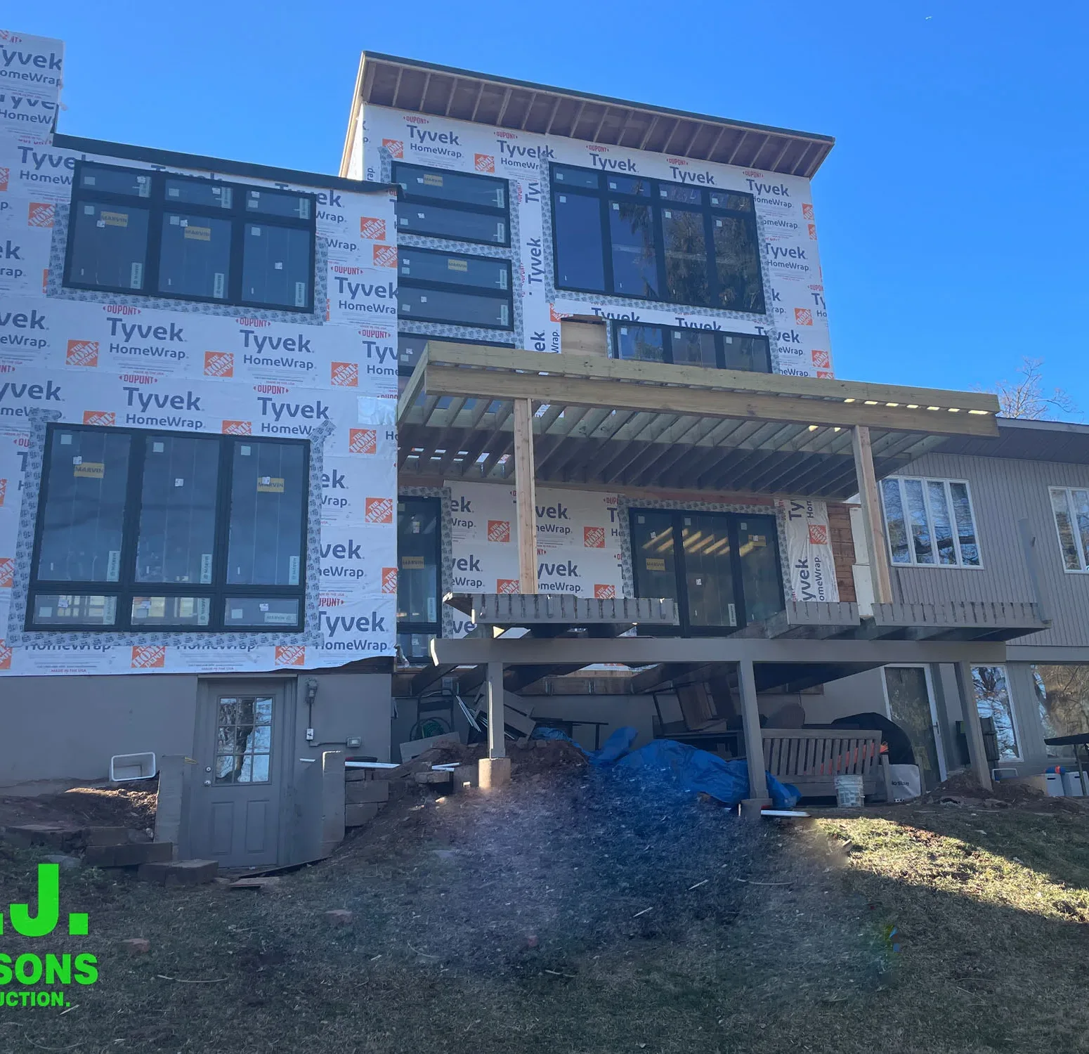 a residential construction site, emphasizing the house in its raw state with house wrap in preparation for the upcoming installation of Nichiha siding