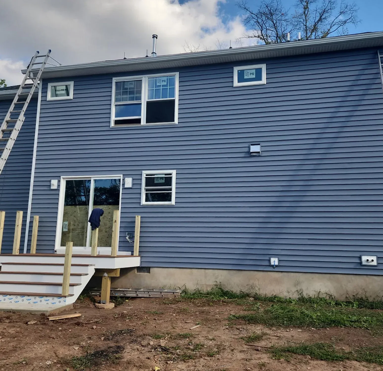 Norandex vinyl siding installation complemented by Azek moldings and trim. The rich, deep blue hue adds sophistication and timeless elegance to your home exterior