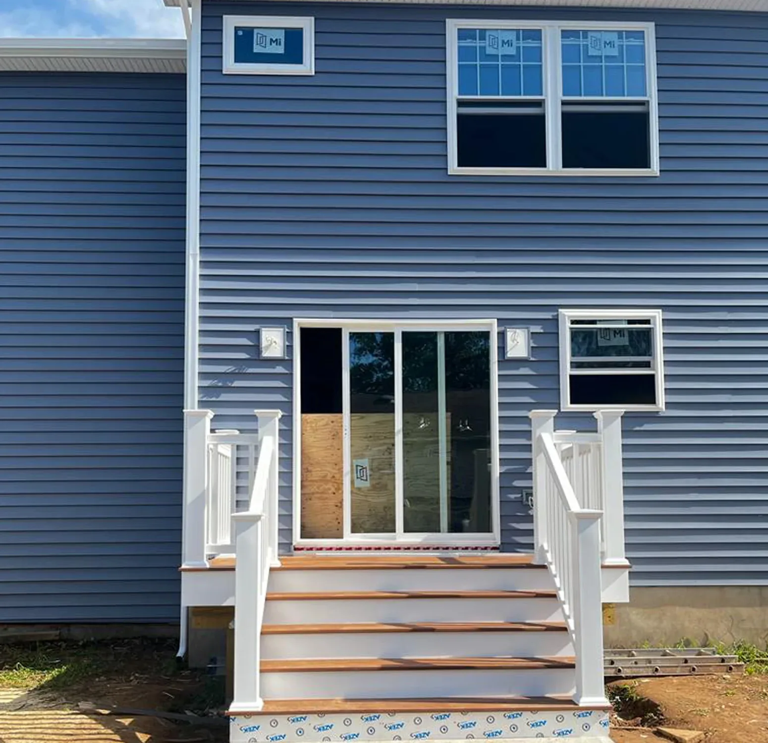 Norandex vinyl siding installation complemented by Azek moldings and trim. The rich, deep blue hue adds sophistication and timeless elegance to your home exterior