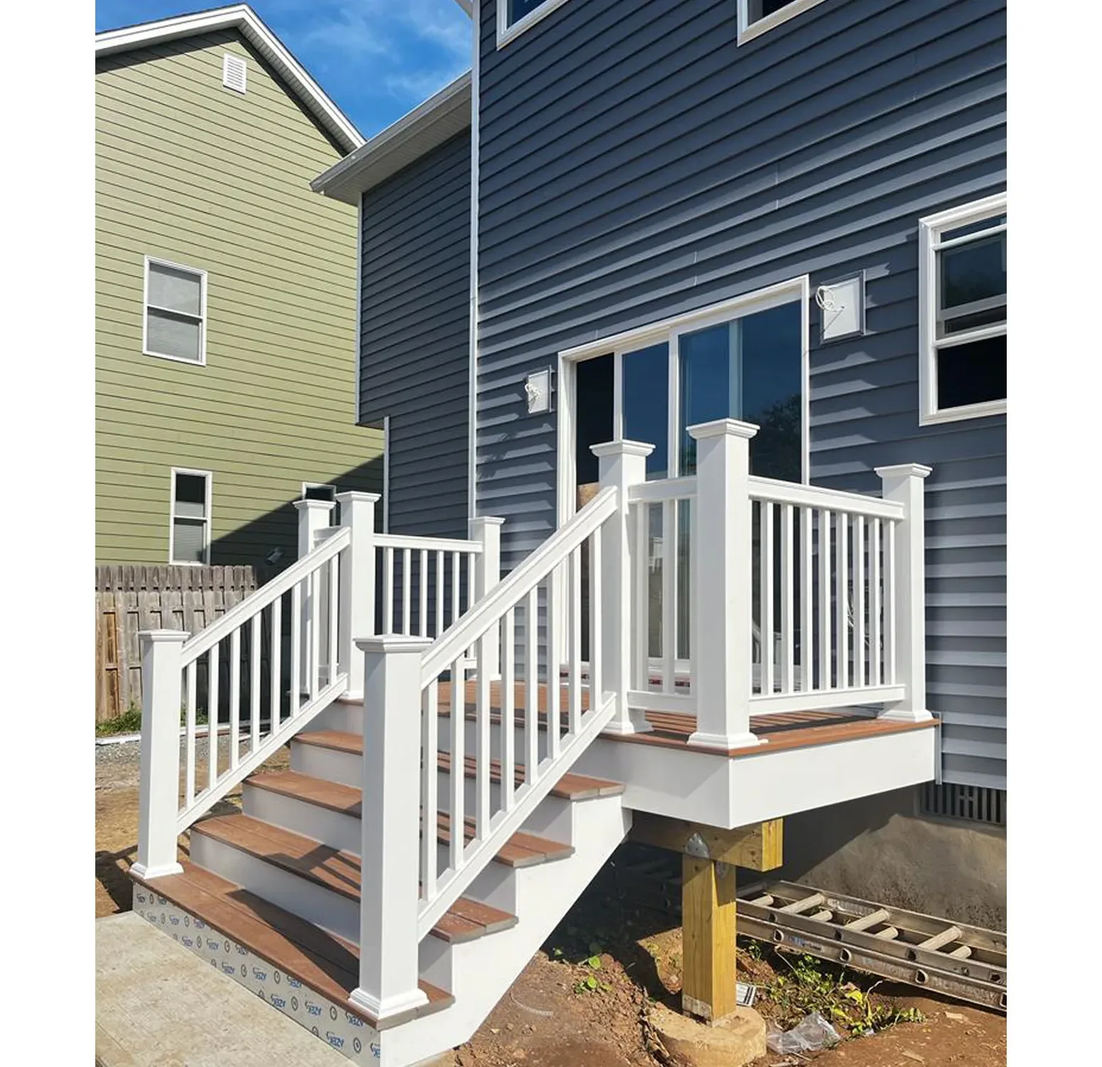 Norandex vinyl siding installation complemented by Azek moldings and trim. The rich, deep blue hue adds sophistication and timeless elegance to your home exterior and vinyl railings with deck