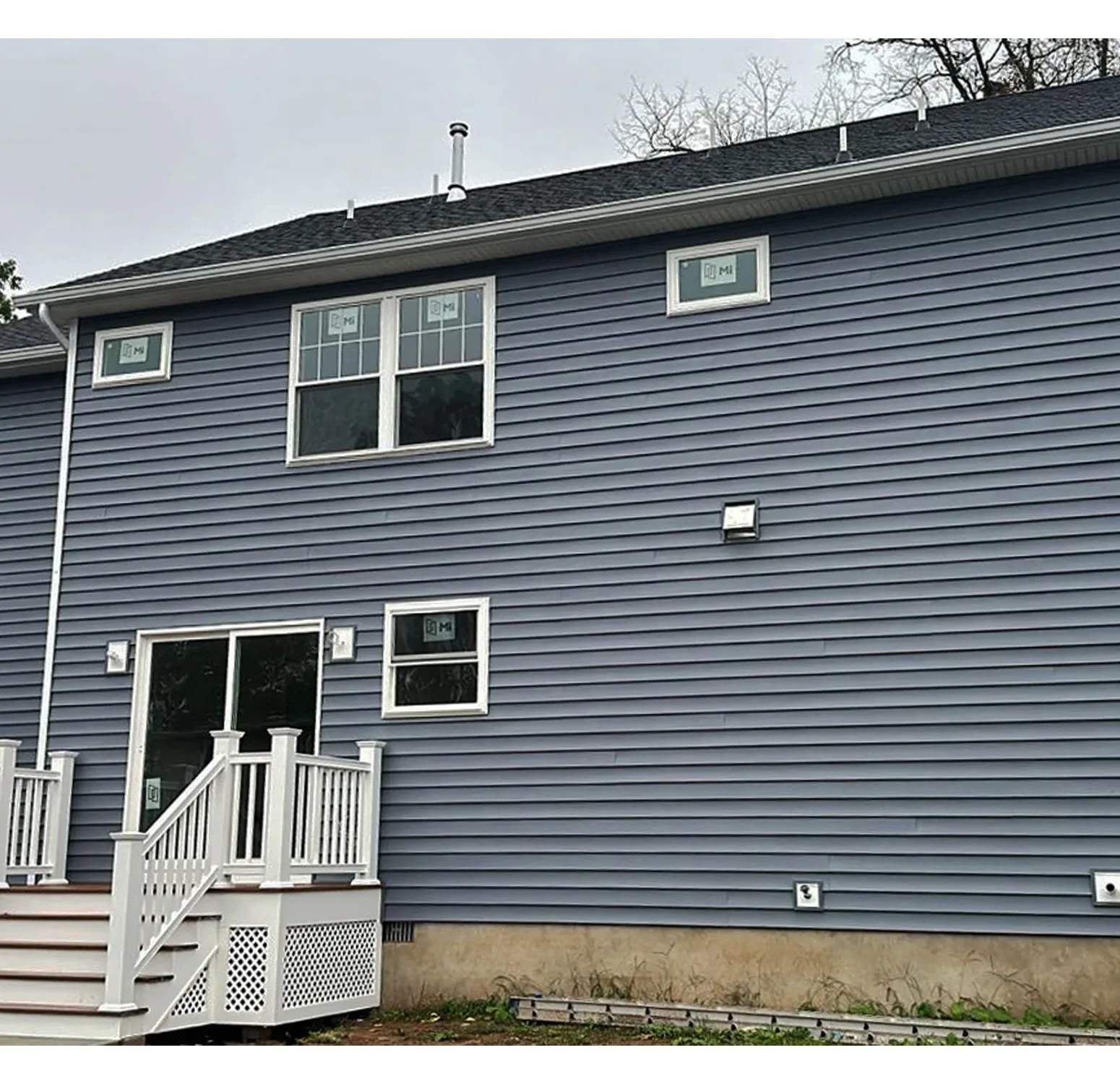 Norandex vinyl siding installation complemented by Azek moldings and trim. The rich, deep blue hue adds sophistication and timeless elegance to your home exterior