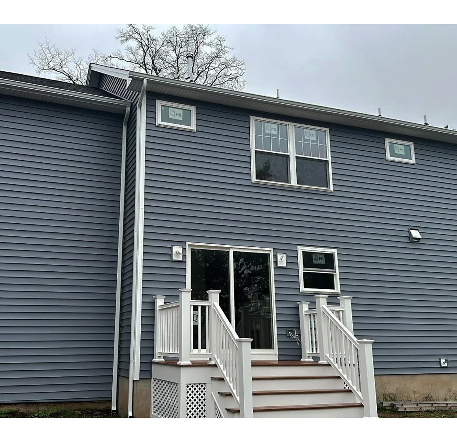 Norandex vinyl siding installation complemented by Azek moldings and trim. The rich, deep blue hue adds sophistication and timeless elegance to your home exterior